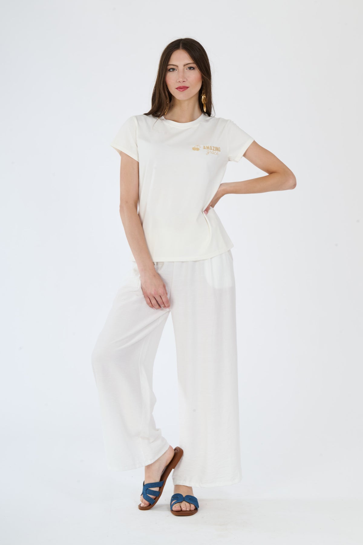 Donna indossa un outfit bianco composto da t-shirt e pantaloni fluidi
