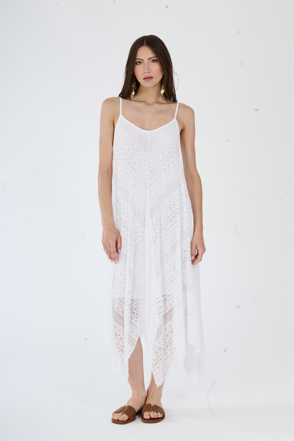 Elegante vestito bianco in maglia a fori, con un taglio asimmetrico che conferisce stile e modernità.