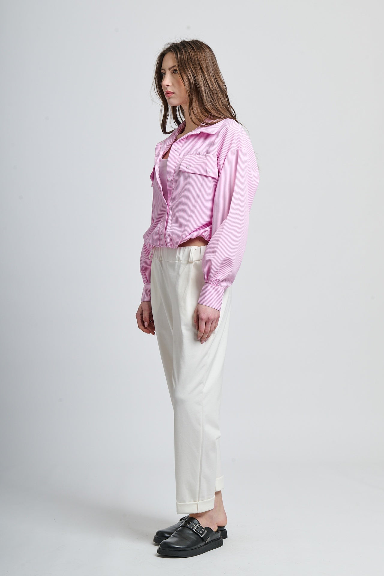 Look moderno: camicia rosa a righe e pantaloni bianchi svasati