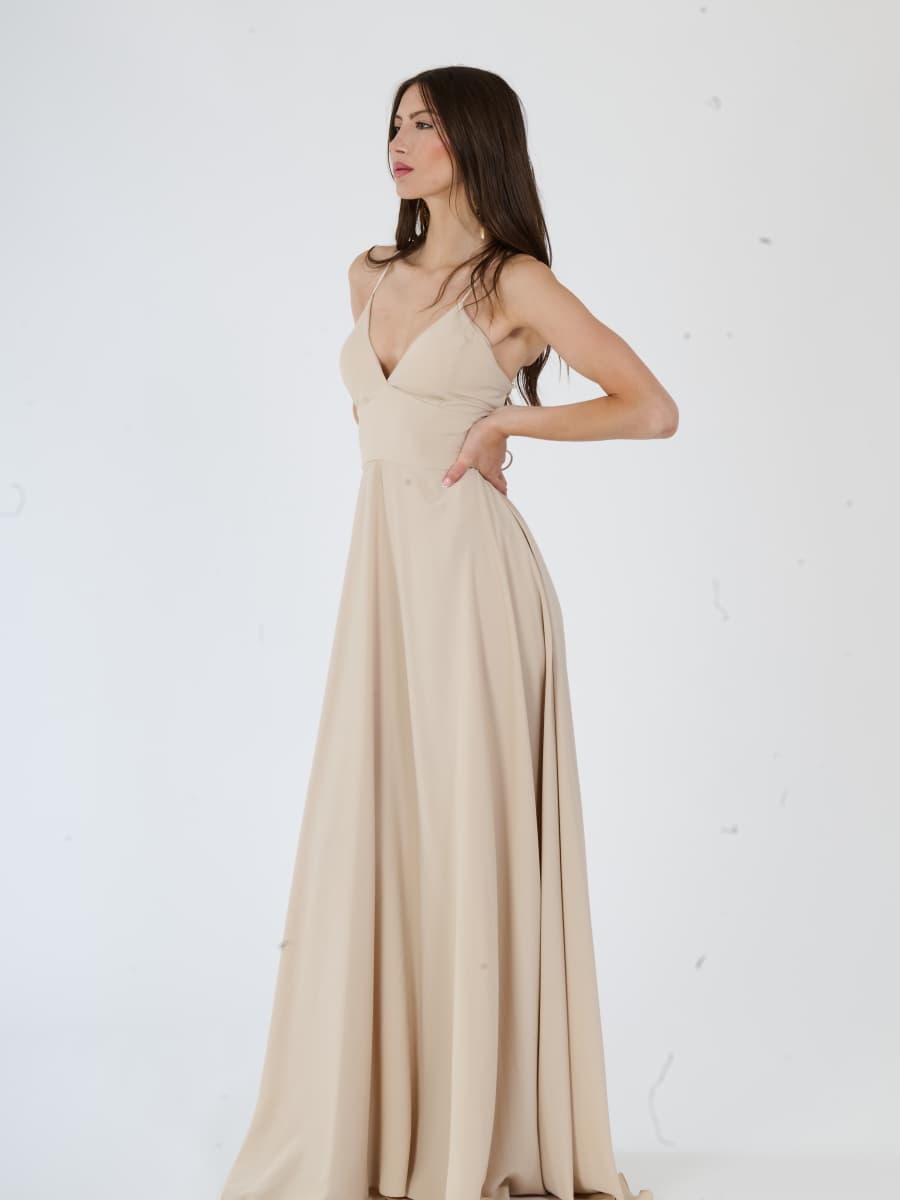 Lungo abito beige con silhouette accattivante e taglio sobrio.