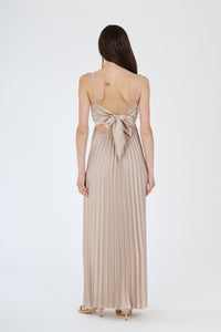 Lungo abito beige plissé con busto avvolgente e gonna fluida, perfetto per occasioni eleganti e confortevoli.