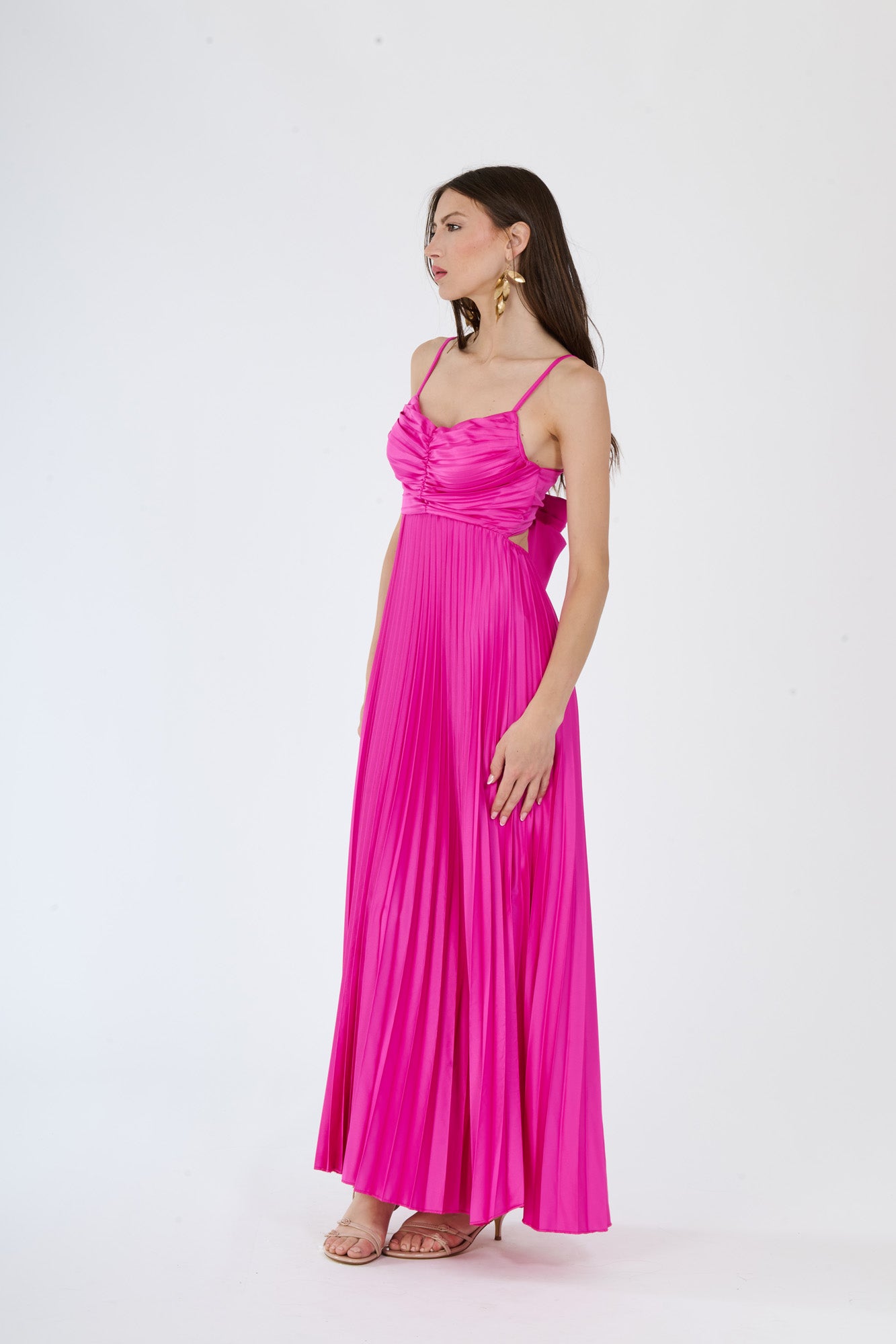 Lungo abito fuxia plissé con busto decorativo e gonna allungata, perfetto per occasioni in cui si vuole stupire.