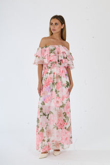 Lungo abito rosa a fiori con spalline a bardot e ruches al busto, perfetto per un look romantico estivo.