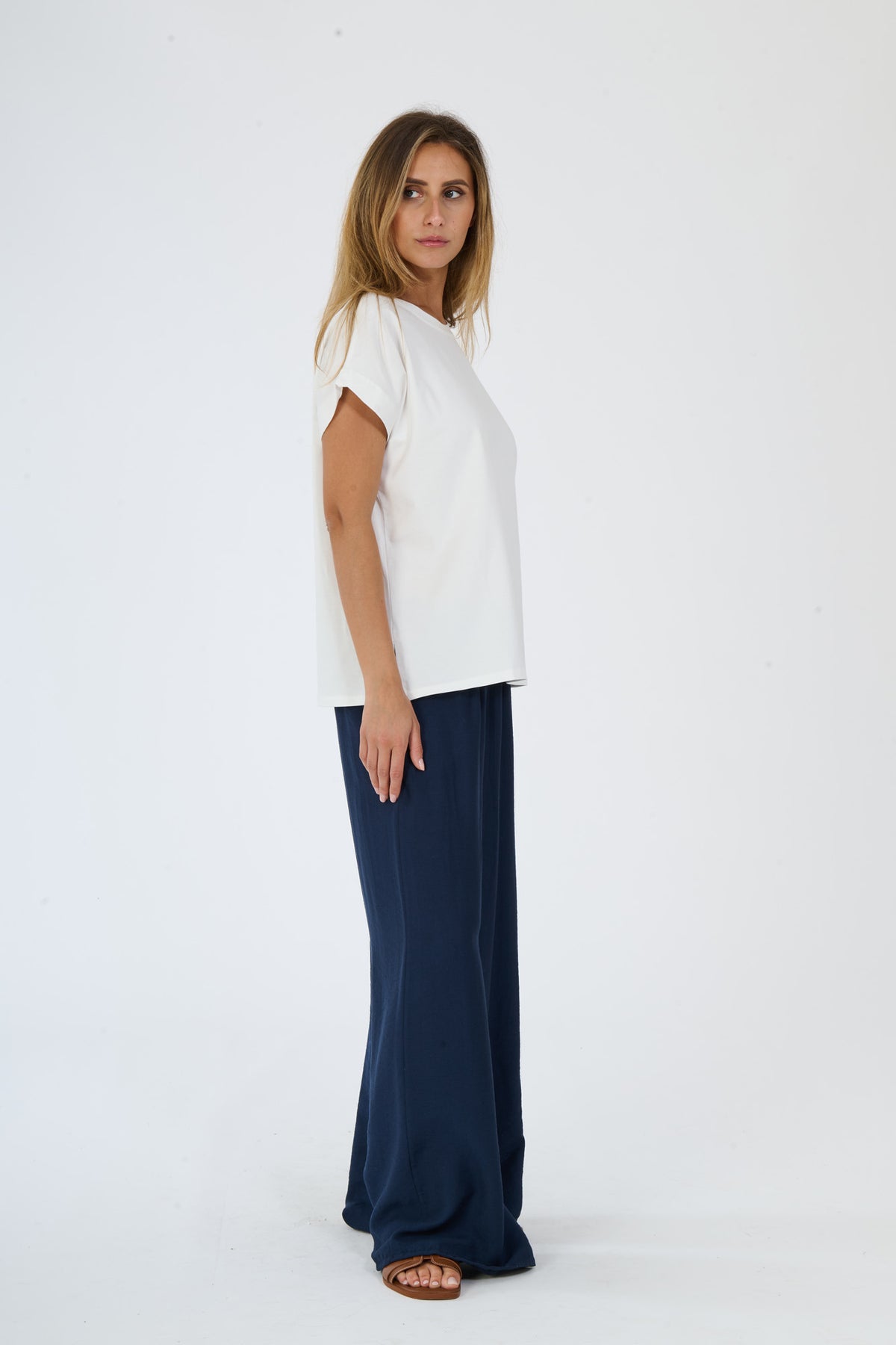 Moda casual beige: t-shirt e pantaloni ampi indossati da una donna elegante