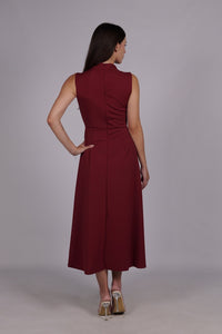 Modella con abito bordeaux a gonna midi, senza maniche, nodo al petto, outfit elegante.
