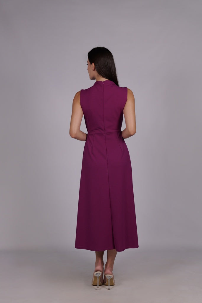 Modella con abito ciliegio a gonna midi, senza maniche, nodo decorativo al petto, outfit elegante.
