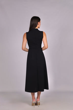 Modella con abito nero a gonna midi, senza maniche, nodo al petto, outfit chic.