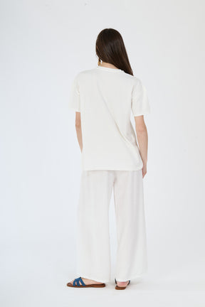 Modella in completo bianco: t-shirt a maniche corte e pantaloni ampi