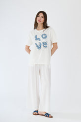 Modella in t-shirt bianco e pantaloni scuri, abbinamento casual