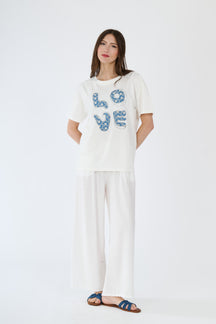Modella in t-shirt bianco e pantaloni scuri, abbinamento casual