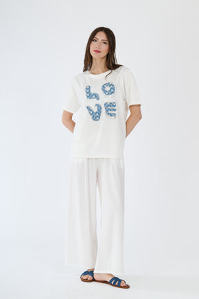 Modella in t-shirt bianco e pantaloni scuri, abbinamento casual