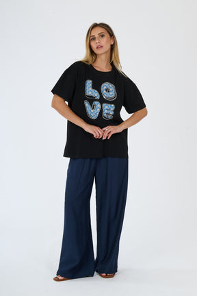 Modella in t-shirt nero e pantaloni scuri, abbinamento casual