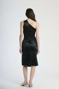 Modella indossa abito nero con plissé, stile iconico per serate notturne.