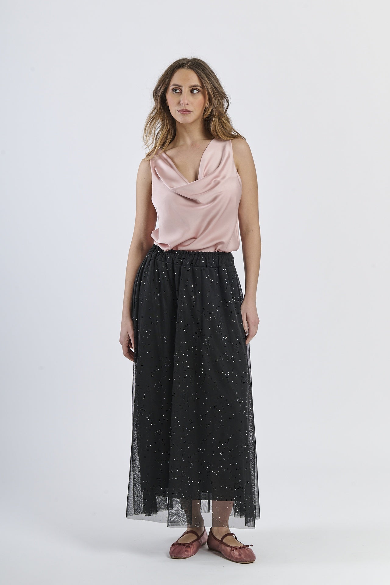 Modello in gonna lunga nero-argento e canotta rosa vivace