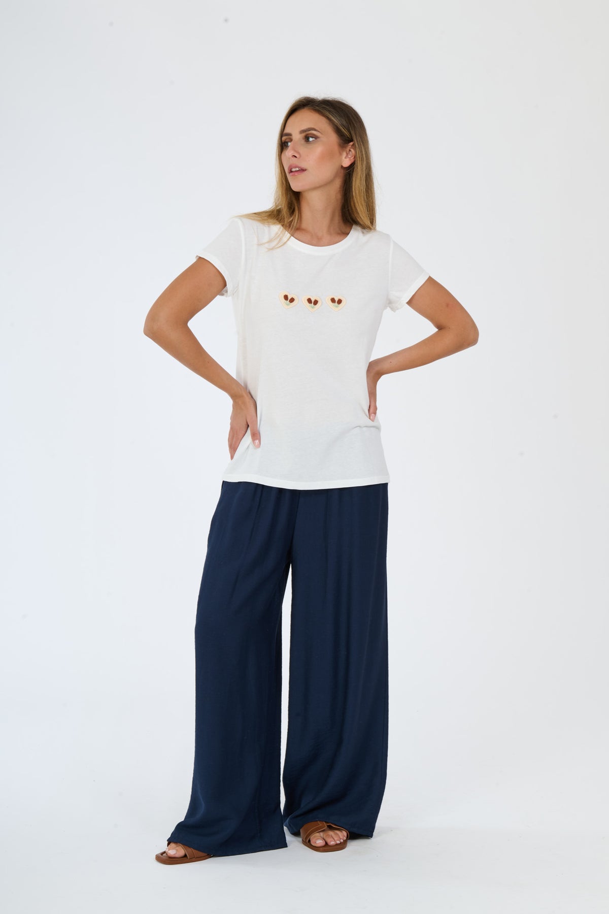 Outfit beige: t-shirt e pantaloni ampi indossati da una modella elegante