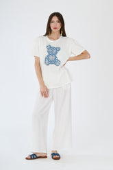 Outfit bianco completo: t-shirt e pantaloni larghi su una donna