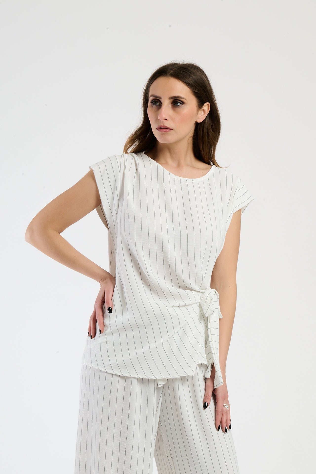 Outfit bianco composto da top e pantaloni, stile pulito e raffinato.