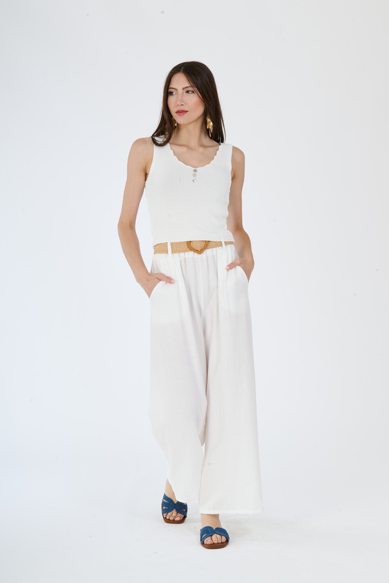 Outfit di top bianco e pantaloni larghi bianchi, perfetto per un’aria leggera e chic in giornate estive.