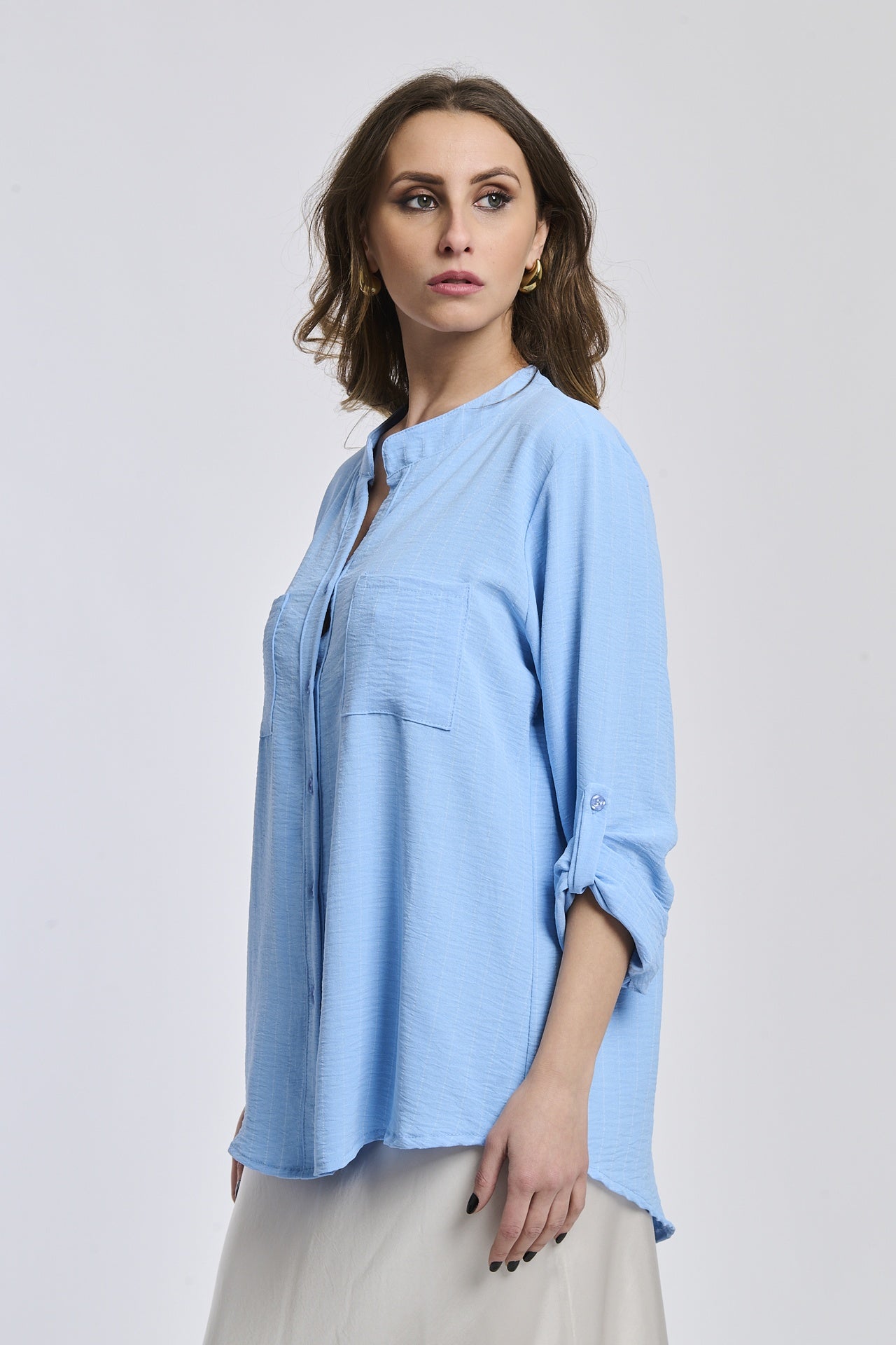 Outfit estivo: camicia azzurra a collo alto, design minimalista e traspirante