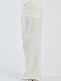 Pantaloni bianchi fluidi con chiusura a bottoni, freschi e confortevoli.