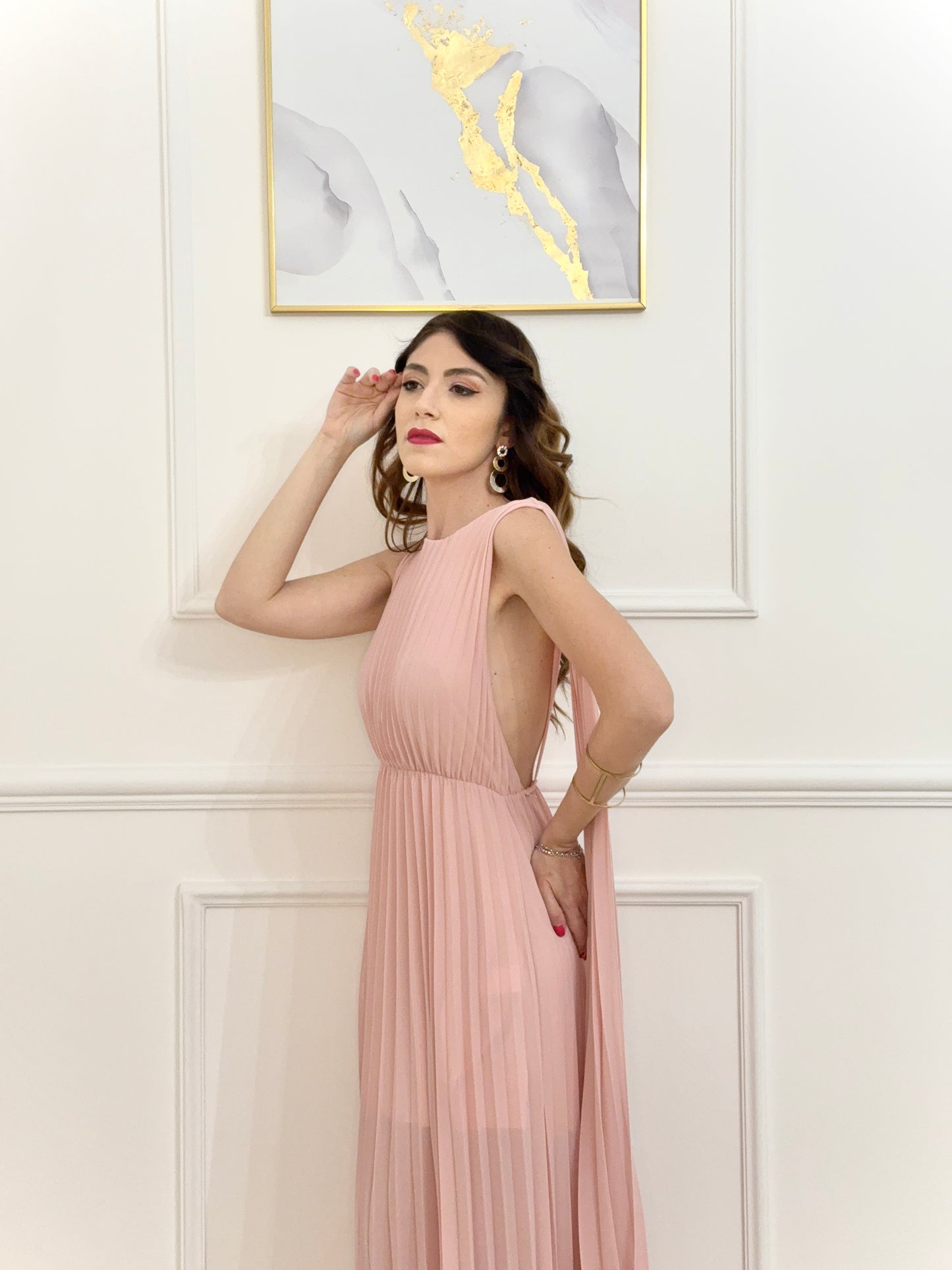 Persona in abito rosa elegante, ambiente lago con montagne verdi