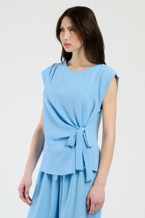 Set azzurro su modella: top a maglia e pantaloni ampi, comfort e eleganza.
