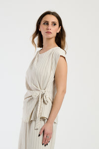 Set beige con top a maglia e pantaloni ampi, comfort e semplicità.