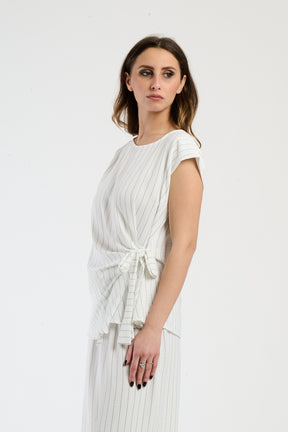 Set bianco con top a maglia e pantaloni ampi, freschezza e comfort.