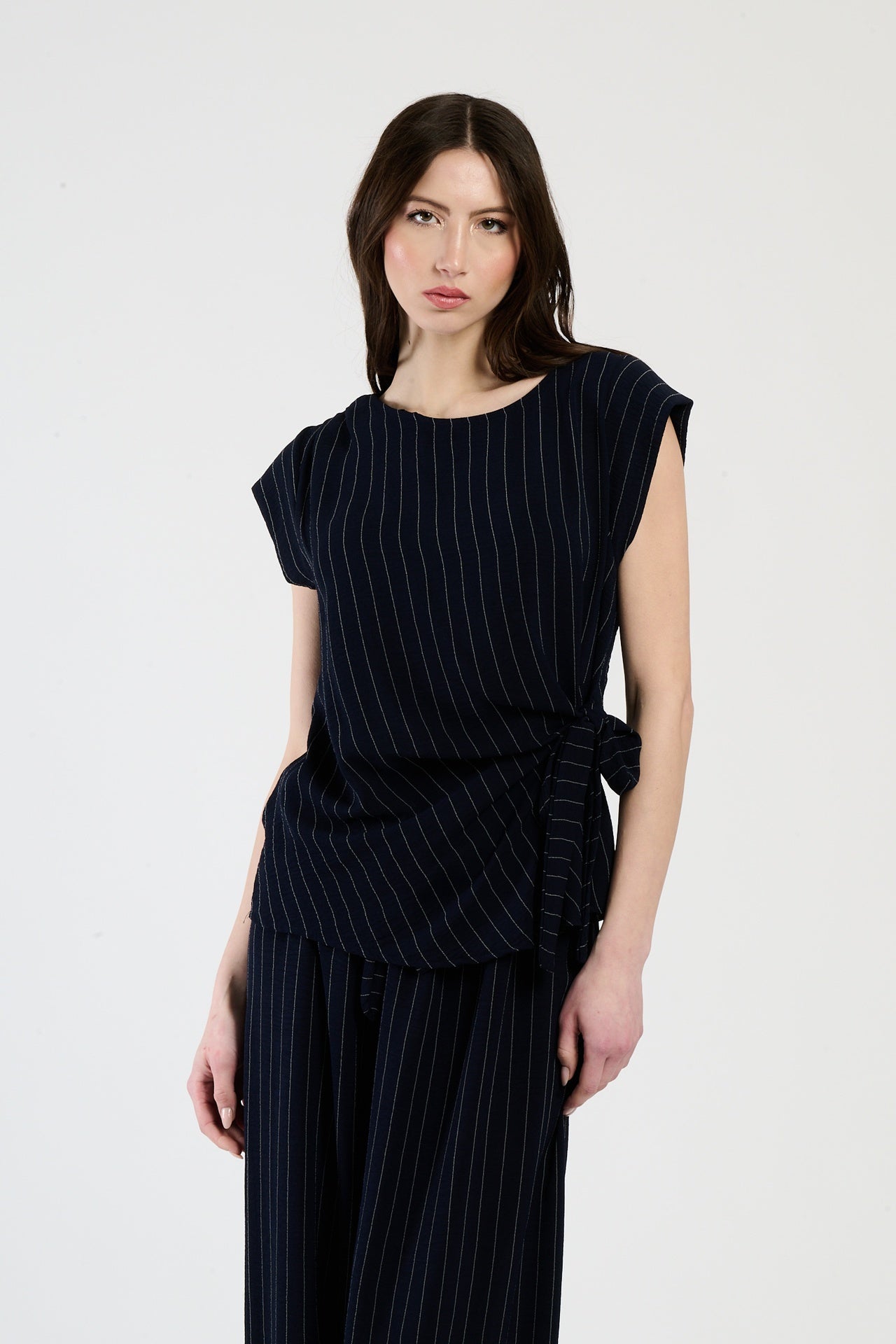 Set nero su donna: top senza spalline e pantaloni, eleganza atemporale e mistero.