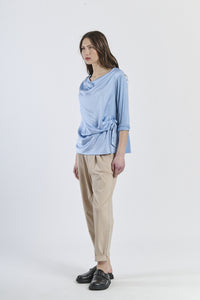 Top azzurro constile fluido e fascia laterale, design raffinato