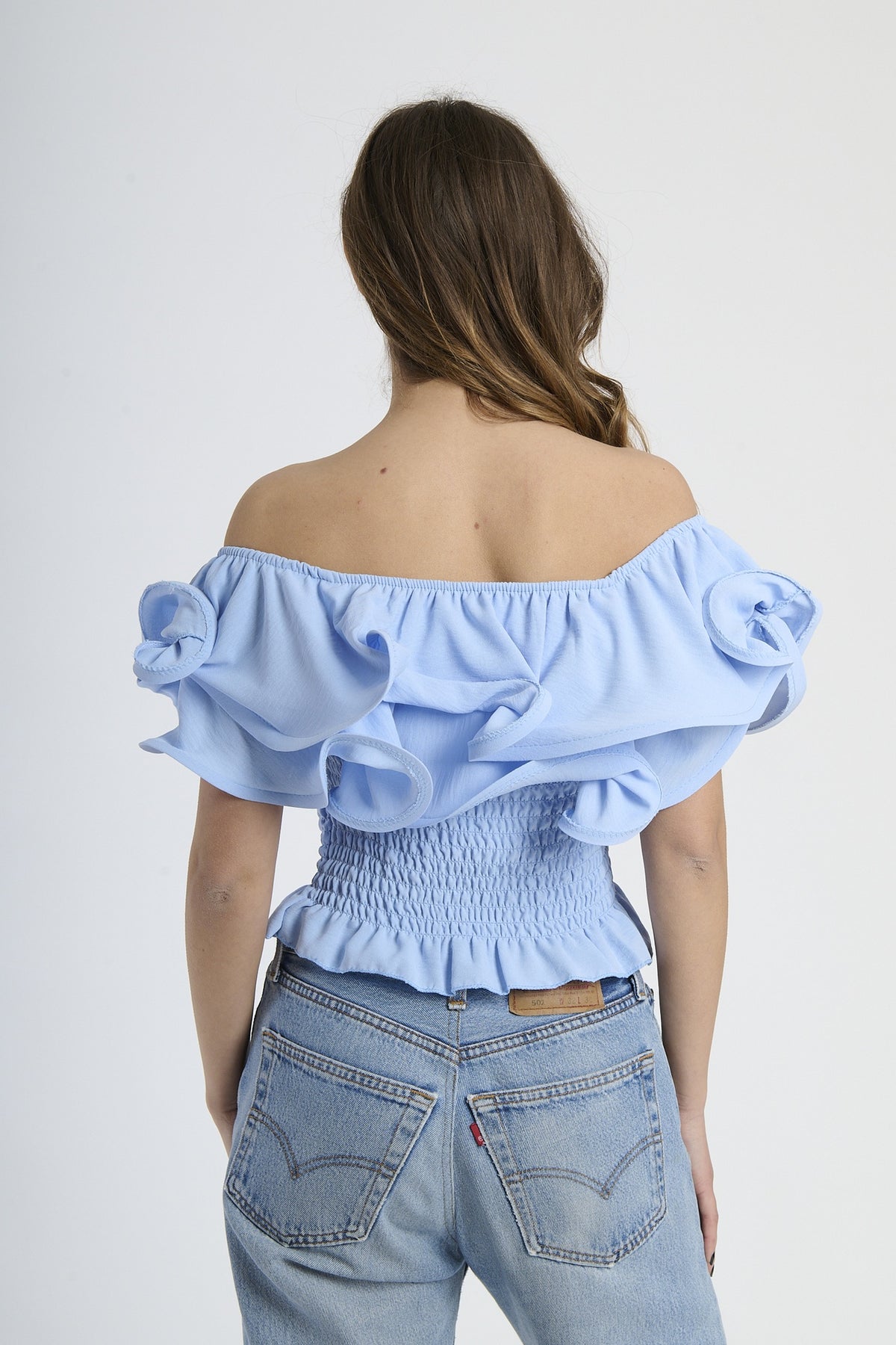 Top azzurro off - shoulder con effetto smocked e rouches, stile elegante e fresco.