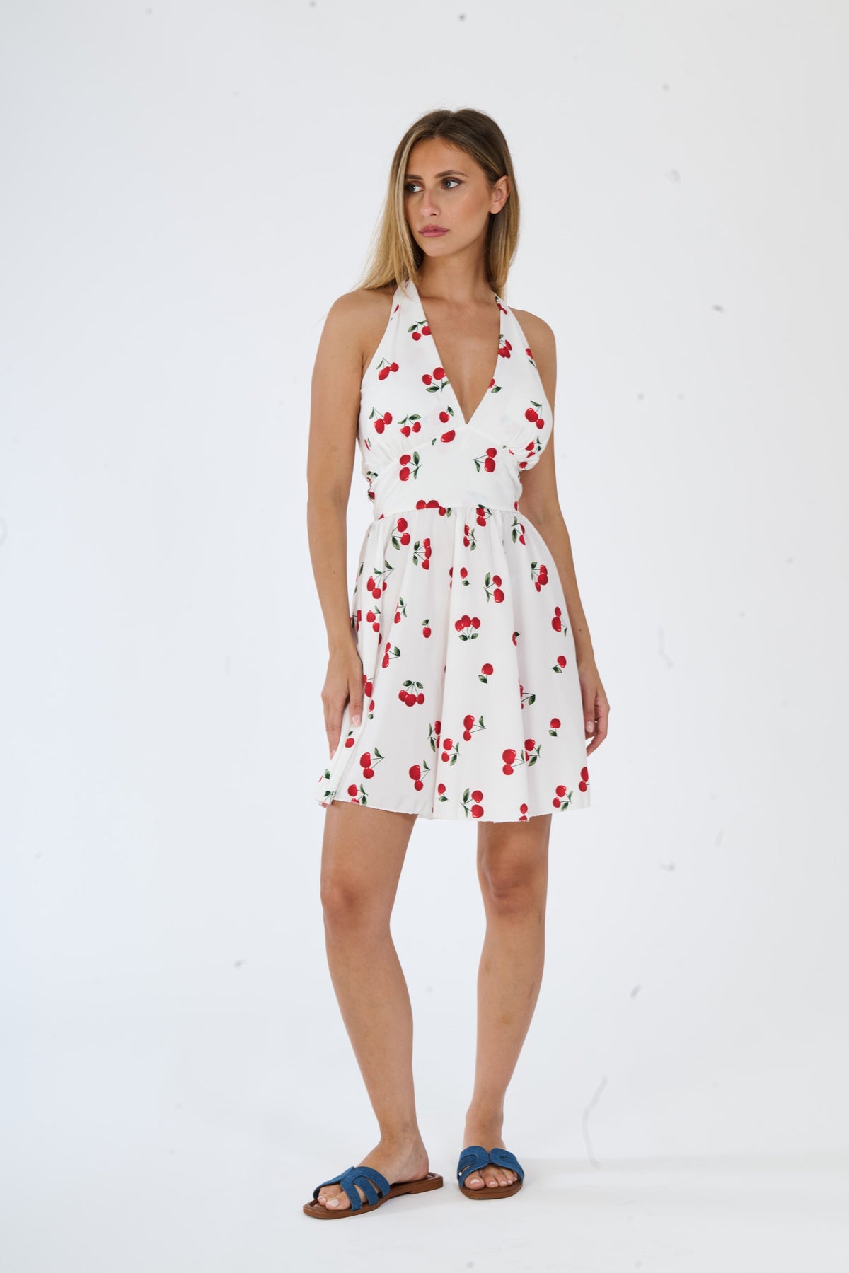 Vestito bianco senza maniche, con spalline larghe e una fascia decorativa alla vita, taglio fluido e lungo.