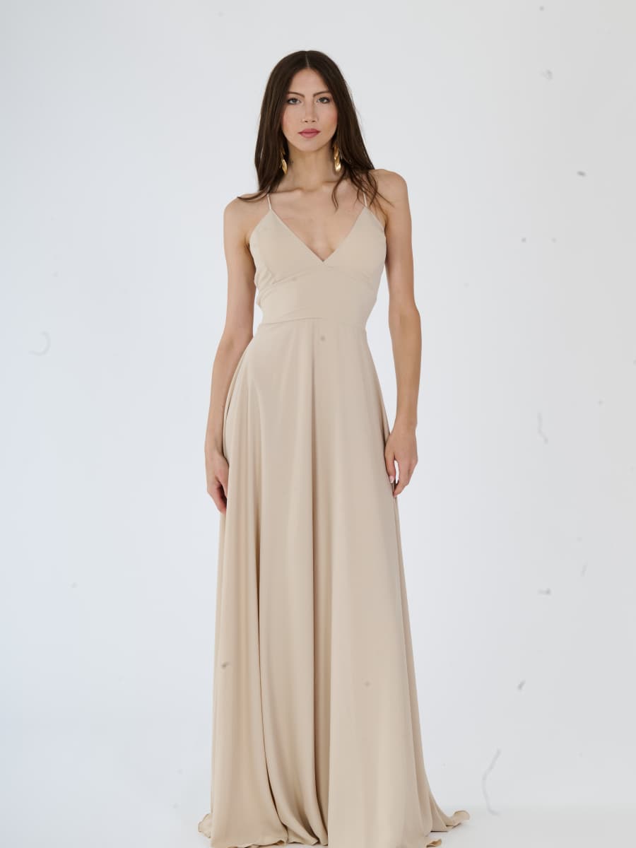 Vestito da sera beige in tessuto fluido, adatto per serate sofisticate.