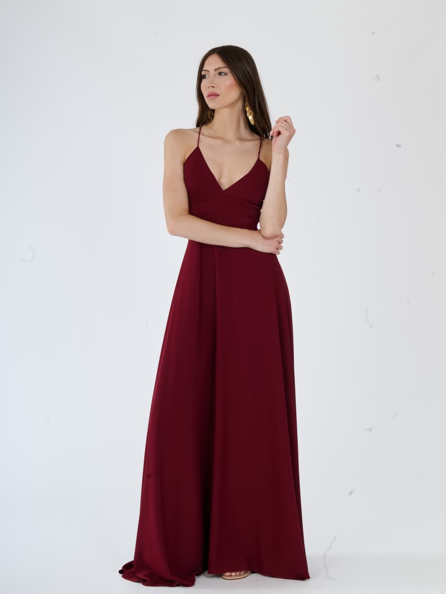 Vestito da sera vino elegante con tessuto fluido e silhouette avvolgente.