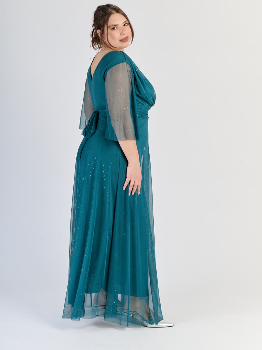 Vestito ottanio fluido in tulle, fascia sulla vita e maniche semi - trasparenti, luce calda e rassicurante