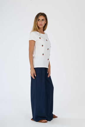 Immagine di una donna con un look bianco: t-shirt e pantaloni ampi
