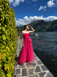 Abito da sera fuxia in tulle vibrante, scollo a barca e gonna ampia, audace per eventi notturni