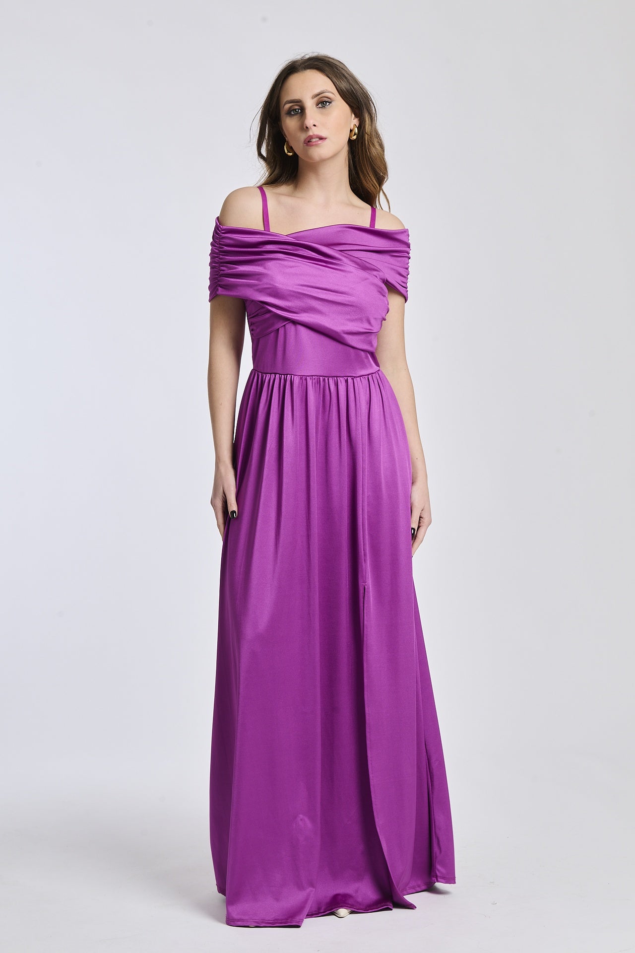 Donna indossa un abito lungo ciliegio, spalline scollate, fascia in vita e apertura laterale romantica.