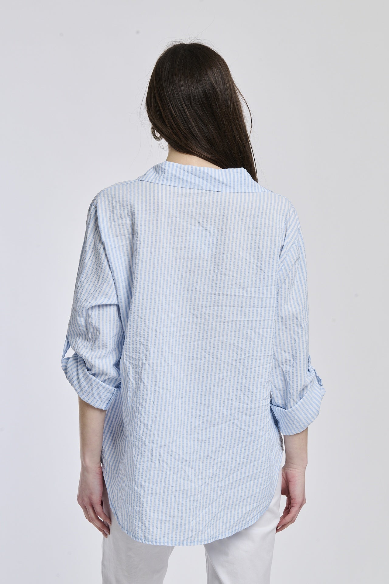 Camicia oversize a righe azzurre, colletto classico, bottoni e maniche arrotolate, stile casual.