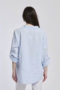 Camicia oversize a righe azzurre, colletto classico, bottoni e maniche arrotolate, stile casual.