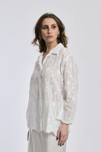 Outfit estivo: camicia bianca traslucida con ricami e gonna bianca, accessori dorati