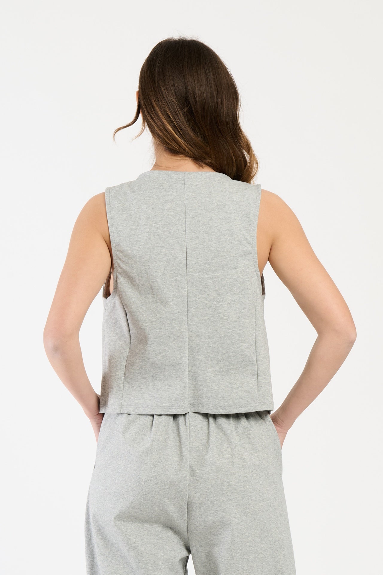 Completo grigio su una modella: gilet a bottoni e pantaloni,