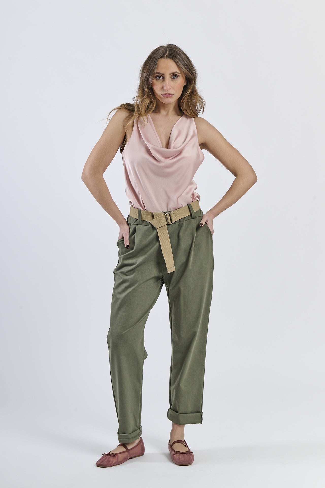 Outfit con top satinato rosa e pantaloni color militare, contrasto stilistico