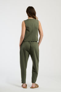 Completo militare su una modella: gilet a bottoni e pantaloni, combinazione robusta e accattivante.