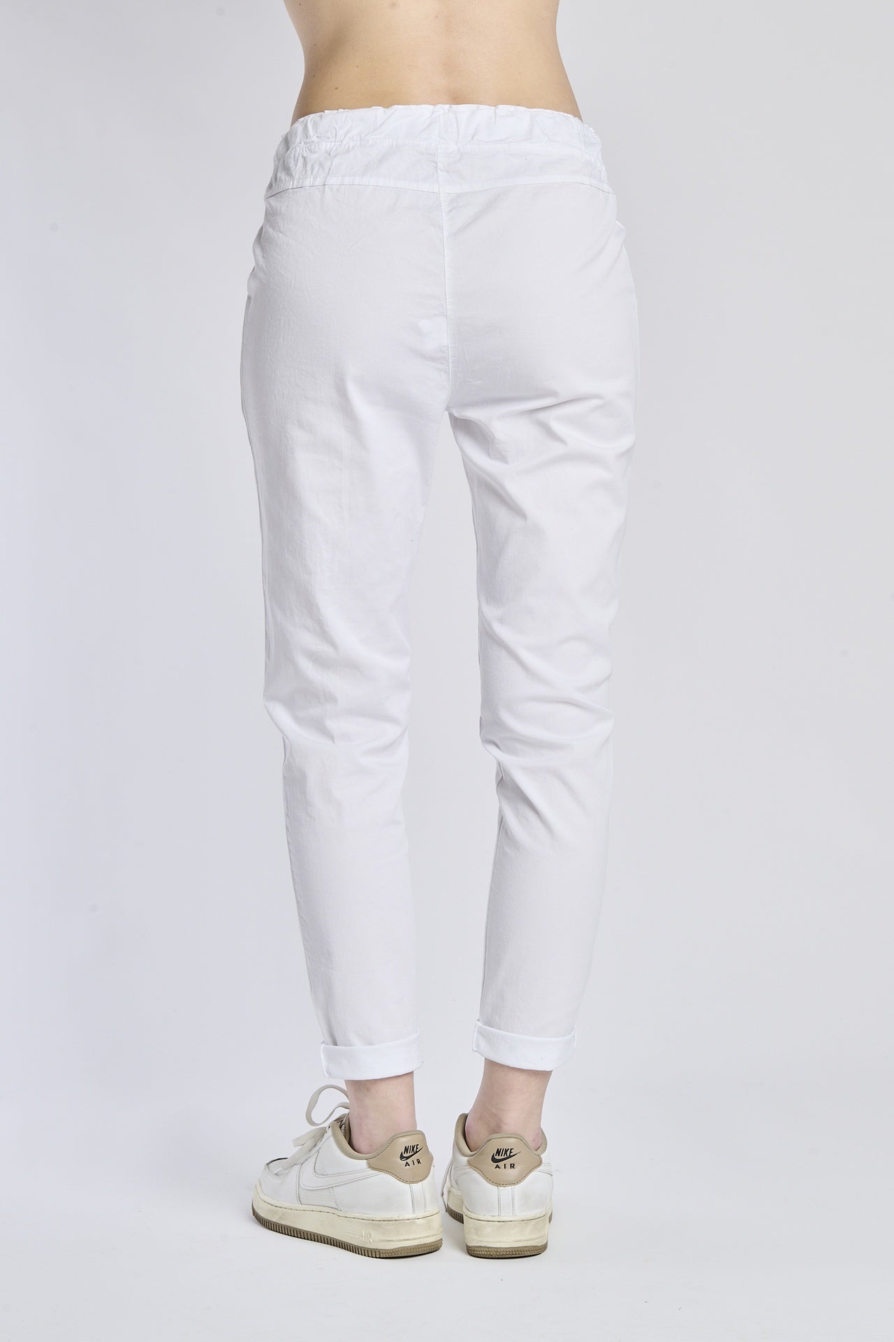 Pantaloni jogger bianchi con coulisse, stile minimalista, abbinati a sneaker bianche