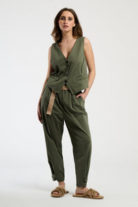 Donna con completo colore militare: gilet e pantaloni, stile ruvido e dal carattere distintivo.