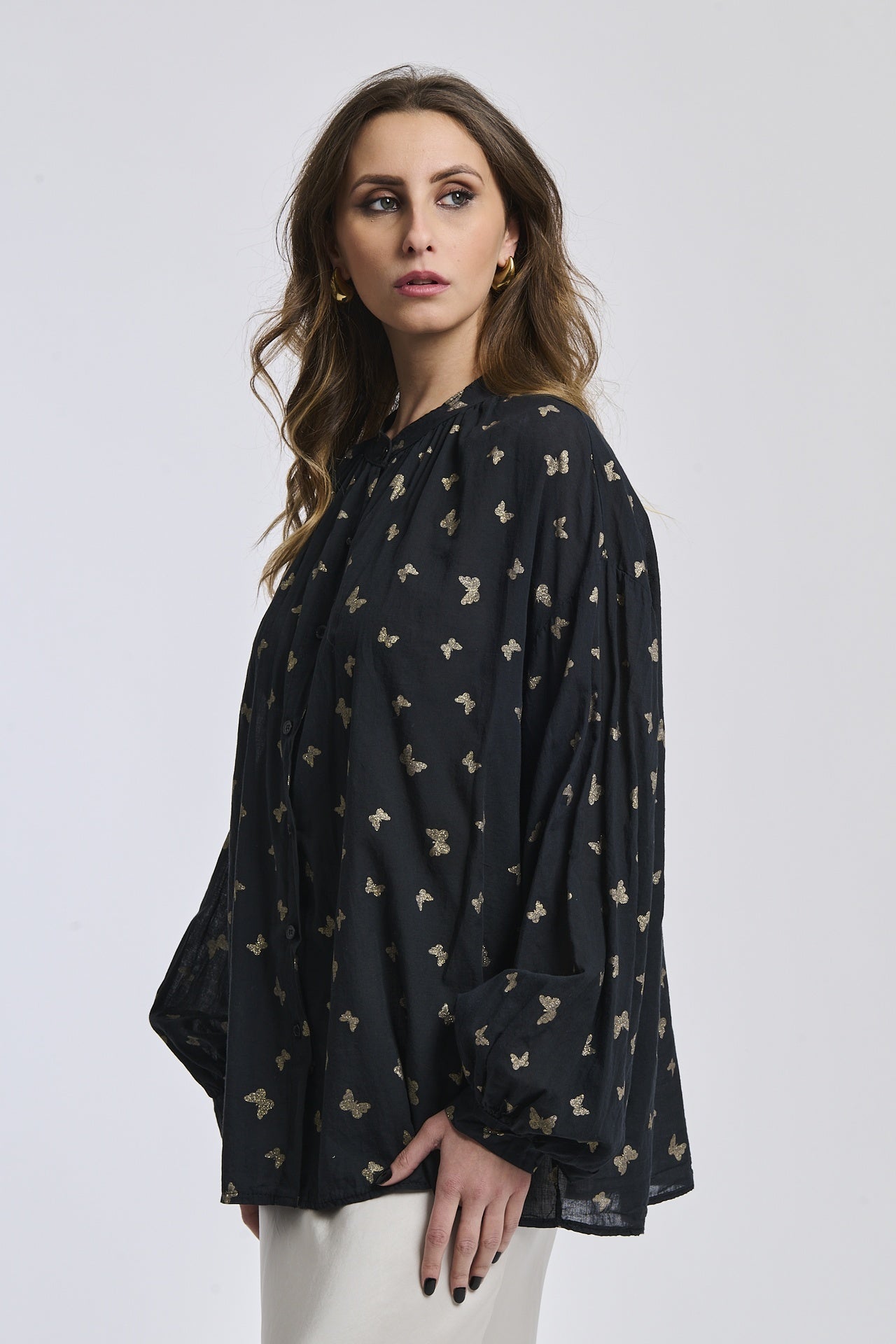 Outfit chic: Camicia nera stampata con collo a imbuto, abbinata a un gonna argento brillante.