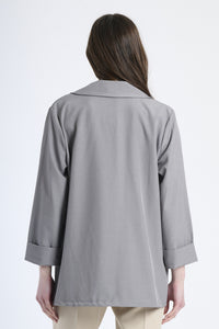 Modella indossa blazer grigio, stile sobrio ed accattivante.