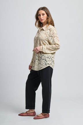 Camicia beige a fantasia, collo classico e maniche lunghe, abbinata a scarpe mocassini.