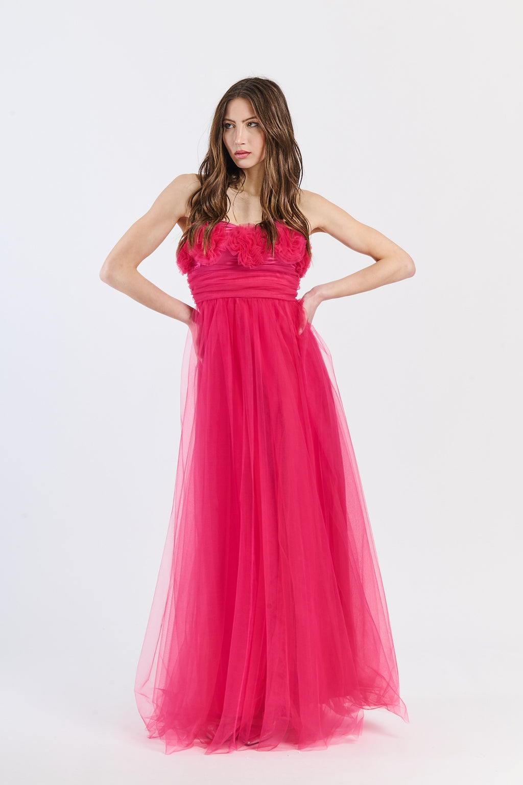 Abito romantico fuxia in tulle luminoso, scollo a barca e drappeggi accesi, perfetto per shoot glamour e serate estive